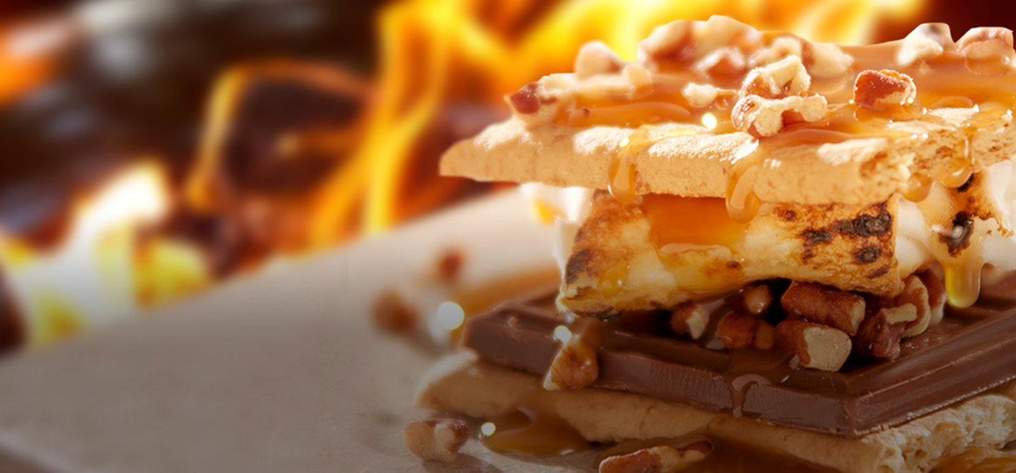 Graham crackers, marshmallow, chocolate, pecan and honey s'mores with flames in background