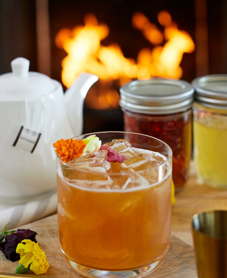 Earl Grey cocktail with fire burning in hearth in background