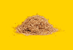 A small pile of sawdust on a bright yellow background