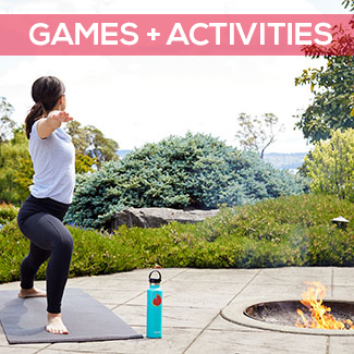 Woman doing yoga near a fire pit with greenery in the background