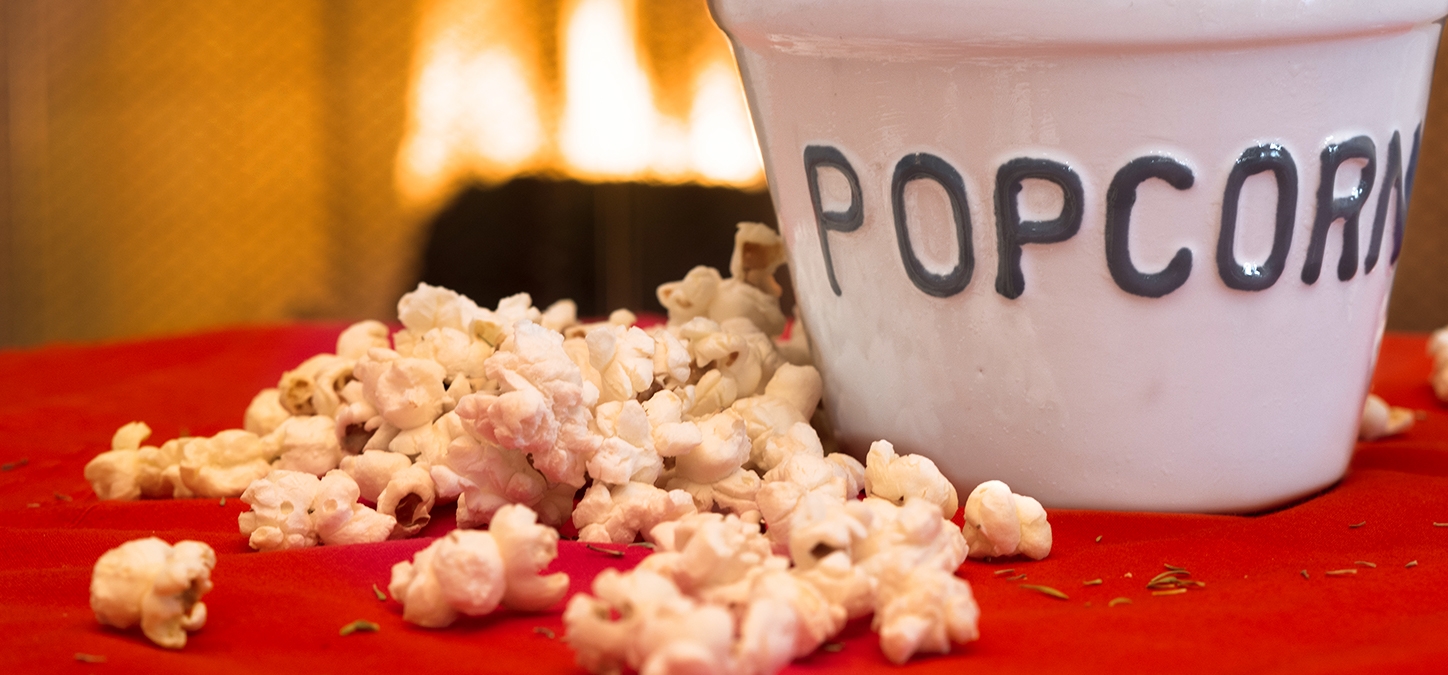 Popcorn overflowing bowl with Duraflame fire burning in background