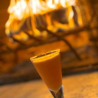 Wellness Shot in glass with duraflame fire in the background
