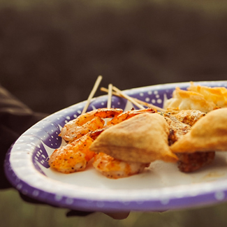 Plate with chicken empanadas, spanikopita and chili garlic shrimp skewers