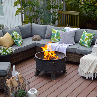 Backyard deck scene with outdoor sectional couch and fire pit burning duraflame OUTDOOR firelogs
