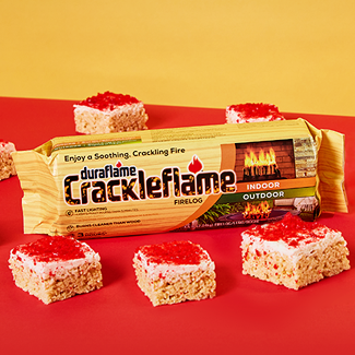 A Crackleflame firelog in its packaging surrounded by Hot Cinnamon Rice Cereal Treats 