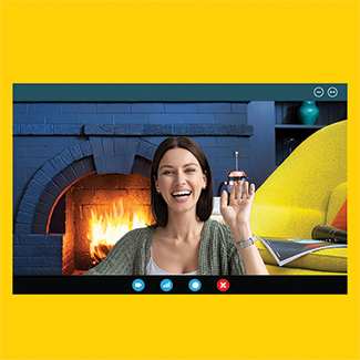 Image of woman smiling on a video call with a duraflame fire virtual background