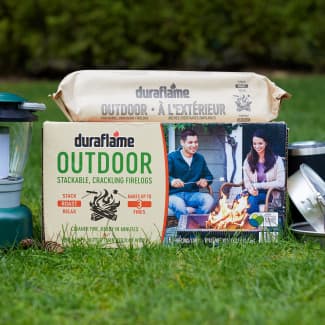 Duraflame OUTDOOR firelog case and log packaging on lawn with camping gear