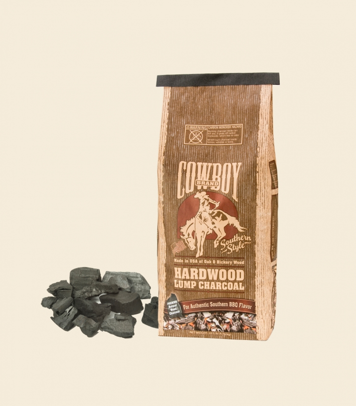 Bag of Cowboy Hardwood Lump Charcoal and pile of raw lump charcoal