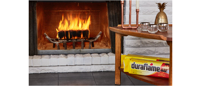 duraflame 6lb firelog buning on grate with table an firelogs next to it