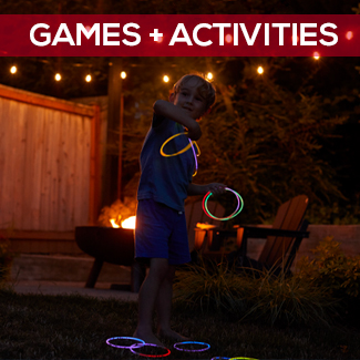 Kid playing glow ring toss by the camp fire